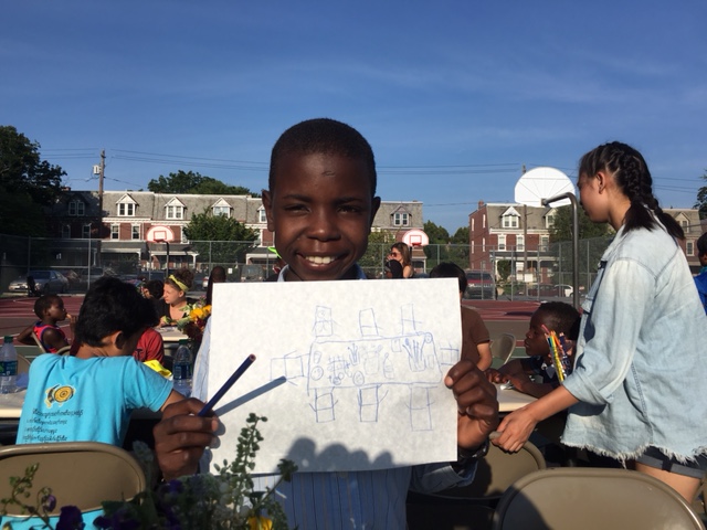 A student at a refugee school in Lancaster County, Pennsylvania, proudly displays his work. Image courtesy of Lancaster Community Foundation 